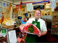 Jim Sutcliffe in Meridian Meats shop with Longhorn ribs of beef.
